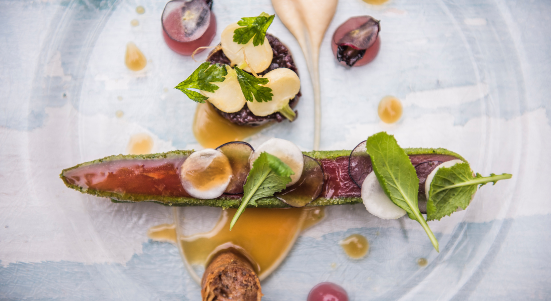 Piatto gourmet vegano in stile fine dining, decorato con ingredienti freschi e di stagione