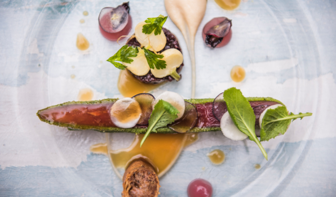 Piatto gourmet vegano in stile fine dining, decorato con ingredienti freschi e di stagione