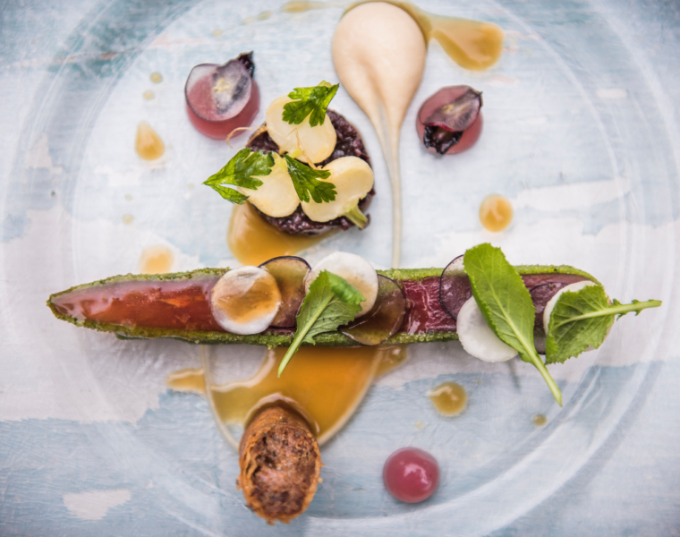 Piatto gourmet vegano in stile fine dining, decorato con ingredienti freschi e di stagione